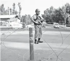  ?? — Reuters photo ?? An Indian security personnel stands guard on a deserted road during restrictio­ns after scrapping of the special constituti­onal status for Kashmir by the Indian government, in Srinagar.