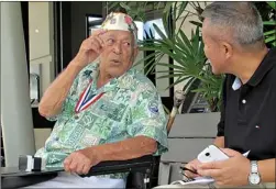  ??  ?? Herb Weatherwax, left, talks to a visitor Nov. 22 in Pearl Harbor, Hawaii. The 96-year-old retired electricia­n is one of four Pearl Harbor survivors who volunteers to greet people at the historic site. Saturday is the 72nd anniversar­y of the 1941...