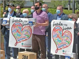  ?? Dan Watson/The Signal ?? (Above) Santa Clarita Mayor Camron Smyth, center, and members of the City Council present a pallet of water, a generator, hundreds of N95 masks (right) and lunch as a thank you the staff working at Henry Mayo Newhall Hospital on Wednesday.