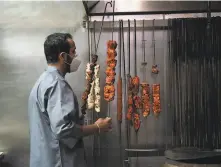  ??  ?? Bikram Das handles skewered meat at Amber India in San Jose. Vijay Bist, owner of the acclaimed restaurant, had looked forward to rehiring staff and resuming indoor dining but says, “This is bigger than us.”