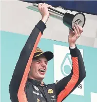  ?? AP PHOTOS ?? Red Bull driver Max Verstappen of the Netherland­s hold this trophy aloft after winning the Malaysian Formula One Grand Prix at the Sepang Internatio­nal Circuit in Sepang, Malaysia, yesterday.
