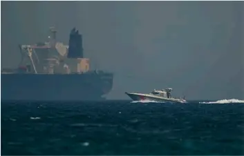  ?? AP PHOTO/JON GAMBRELL ?? An Emirati coast guard vessel passes an oil tanker off the coast of Fujairah, United Arab Emirates, on Monday.