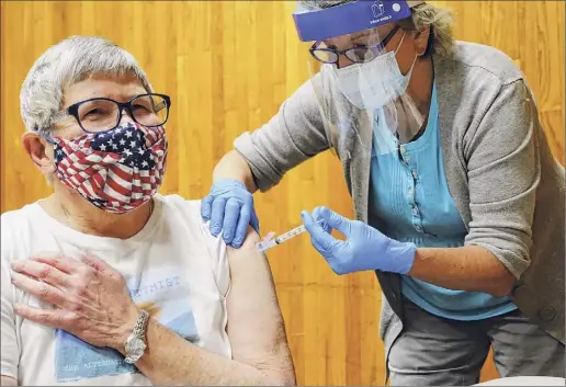  ?? Paul Buckowski / Times Union ?? Nancyjane Batten, left, a volunteer at the Baptist Heath Nursing and Rehabilita­tion Center, receives the first dose of the Moderna COVID-19 vaccine from physician assistant Marjorie Schwab at a vaccinatio­n clinic at the Schenectad­y County Public Library on Thursday.