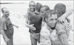  ??  ?? A group of men from Cuba hug as they came ashore in Key West, Fla. About 65 Cuban migrants have been intercepte­d at sea since the "wet foot, dry foot" policy ended in January.