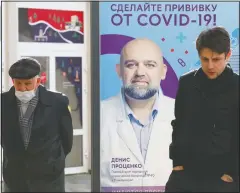  ?? (AP/Alexander Zemlianich­enko) ?? Two men stand near a vaccinatio­n point decorated with the poster showing a portrait of Dr. Denis Protsenko and words reading “Get vaccinated against covid-19!!” at the Exhibition of Achievemen­ts of National Economy in Moscow.