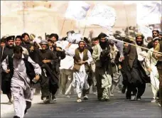  ??  ?? Afghan refugees charge towards journalist­s in Pakistan in 2001