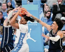  ?? Grant Halverson/Getty Images ?? Armando Bacot, second from left, dominated with 25 points and pulled down 10 rebounds as No. 3 North Carolina beat No. 7 Duke 93-84.