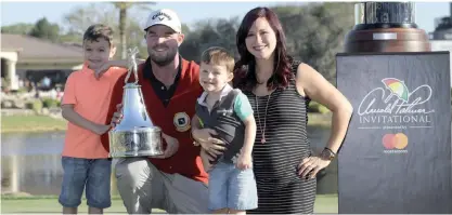  ??  ?? ORLANDO: Marc Leishman, of Australia, poses with his family, while holding the championsh­ip trophy after winning the Arnold Palmer Invitation­al golf tournament in Orlando, Fla., Sunday. With Leishman are sons, Harvey, 5, left, and Oliver, 3, and wife, Audrey. —AP