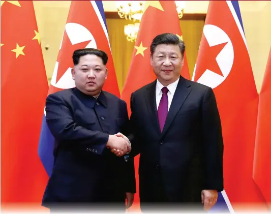  ?? Photo: Xinhua ?? Xi Jinping, general secretary of the Central Committee of the Communist Party of China and Chinese president, shakes hands with Kim Jong-un, chairman of the Workers’ Party of Korea and chairman of the State Affairs Commission of the Democratic People’s...