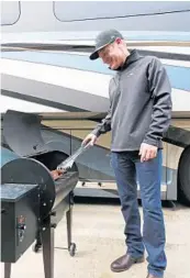  ?? RICARDO RAMIREZ BUXEDA/STAFF PHOTOGRAPH­ER ?? Clint Bowyer barbecues ribs outside his motorhome in the infield of Daytona Internatio­nal Speedway on Thursday.