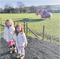  ??  ?? Isla Wilson with her younger sister Ailish and the air ambulance.