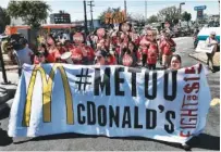  ?? AP FILE PHOTO/RICHARD VOGEL ?? McDonald’s workers carry a banner and march toward a McDonald’s in south Los Angeles.