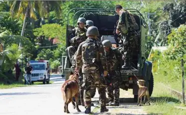  ?? AFP PIC ?? Soldiers and K9 dogs disembarki­ng from a vehicle to search for militants in Bohol island, the Philippine­s, on Saturday.