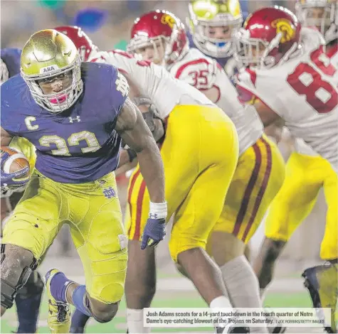  ?? | JOE ROBBINS/ GETTY IMAGES ?? Josh Adams scoots for a 14- yard touchdown in the fourth quarter ofNotre Dame’s eye- catching blowout of the Trojans on Saturday.