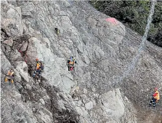  ??  ?? ABOVE: Abseilers at Ohau Point, north of Kaikoura, shackle on another 50-square metre panel of ring net to secure the unstable rock face. RIGHT: Abseilers at the top, with a view down to the Pacific Ocean.