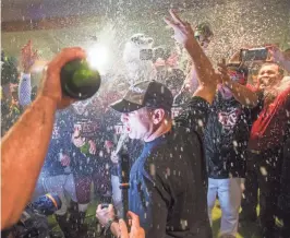  ??  ?? Diamondbac­ks manager Torey Lovullo celebrates with his team after Arizona clinched a playoff berth with Sunday’s 3-2 win over the Marlins.