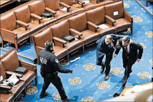  ?? DREW ANGERER/GETTY ?? Members of Congress run for coverWedne­sday as protesters try to enter the House Chamber during the joint session to ratify President-elect Joe Biden’s 306-232 Electoral College win over President Donald Trump.