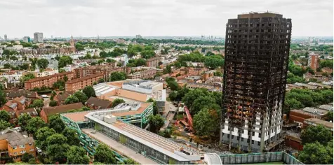  ?? Foto: Niklas Halle’n, afp ?? Der Grenfell Tower überragt den Westen Londons noch immer. Doch es blieb nur ein schwarzes Skelett.