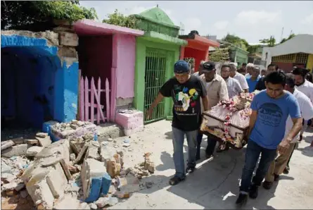  ?? REBECCA BLACKWELL — THE ASSOCIATED PRESS ?? Men carry the coffin of 64- year- old Reynalda Matus on Saturday past earthquake debris inside Miercoles Santo Cemetery in Juchitan in Oaxaca state, Mexico. Matus was killed when the pharmacy where she worked nights collapsed during Thursday’s massive...