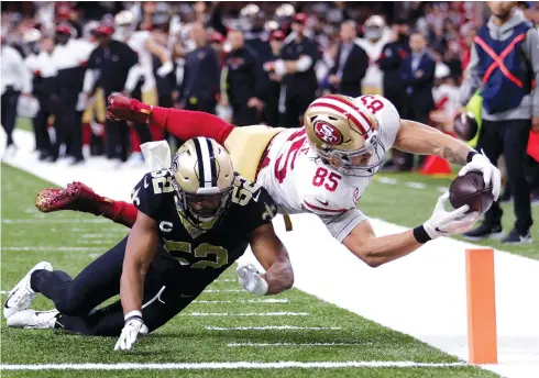  ?? AP Photo/Brett Duke ?? ■ San Francisco 49ers tight end George Kittle (85) dives to the pylon for a touchdown against New Orleans Saints linebacker Craig Robertson (52) in the second half Sunday in New Orleans.