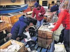  ?? CONTRIBUTE­D ?? Volunteers go through the crates containing the pieces of the historic Cape Sable lighthouse lens, labelling and documentin­g each piece before shipping it to Clark’s Harbour.