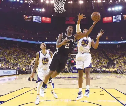  ?? AP FOTO ?? GETTING THROUGH. San Antonio Spurs forward Kawhi Leonard shoots in front of Warriors forward Matte Barnes (left) and forward David West (right) during first half of Game 1 on the NBA Western Conference finals. Leonard re-injures his tender left ankle...