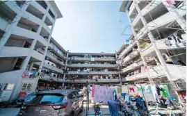  ??  ?? The ring-shaped Longchang Apartment has long been a tourist favorite, much to residents’ despair.