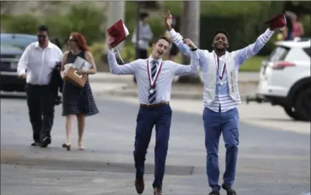  ?? LYNNE SLADKY — THE ASSOCIATED PRESS ?? Graduates leave a graduation ceremony for Marjory Stoneman Douglas seniors, Sunday in Sunrise, Fla. The senior class from Florida’s Parkland high school where a gunman killed 17 people in February received diplomas Sunday and heard from surprise...