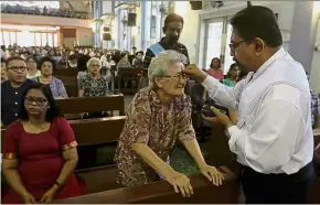  ??  ?? Holy day: The blessing and distributi­on of ash during mass on Ash Wednesday at the Church of Our Lady of Sorrows in Penang.