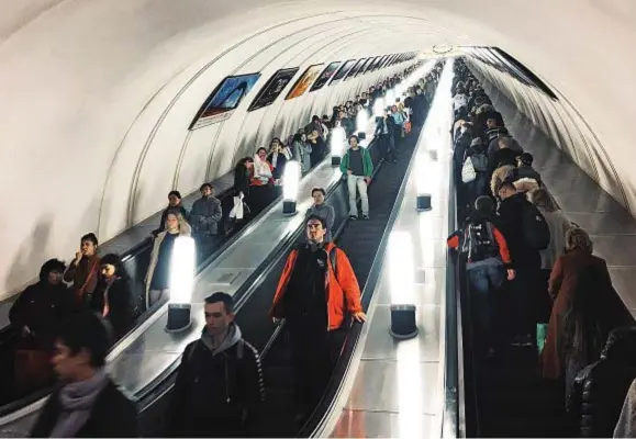  ??  ?? Passeggeri sulle scale mobili all'interno della metropolit­ana di Mosca: lo stadio Lužniki, dove gioca lo Spartak, ospiterà sia il match inaugurale sia la finale.