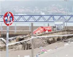  ??  ?? A police investigat­or inspects the seafront platform in Vigo on Sunday after a section of a wooden promenade suddenly collapsed with people watching a rap artist just before midnight on Sunday. More than 370 were injured, including nine seriously, the regional government of Galicia said in a statement.