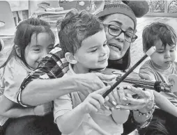  ?? PHOTOS COURTESY OF HARMONY PROJECT PHOENIX ?? An instructor teaching a child how to use an instrument.