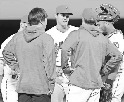  ?? SEAN M. HAFFEY/GETTY IMAGES ?? Pitching coach Charles Nagy, right in foreground, balances all of the starters’ workloads and schedules so Shohei Ohtani, center, gets a start each week between DH roles.