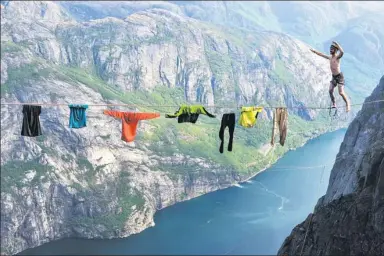  ?? FRED MARIE / SOLENT NEWS ?? Paul-Antoine Gauchon, 28, walks on a tightrope strung across a Norwegian fjord at a height of about 1,000 meters. Gauchon started the 30-meter walk after hanging his clothes on the line.