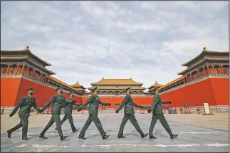  ?? (File Photo/AP/Andy Wong) ?? Soldiers wearing protective face masks march on March 12, 2020, past the closed entrance gates to the Forbidden City, usually crowded with tourists before the coronaviru­s outbreak in Beijing.