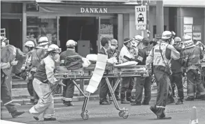  ?? YUKIE NISHIZAWA/KYODO NEWS VIA AP ?? First responders carry a stretcher after a deadly fire at an eight-story building in a major business, shopping and entertainm­ent district in Osaka, western Japan.