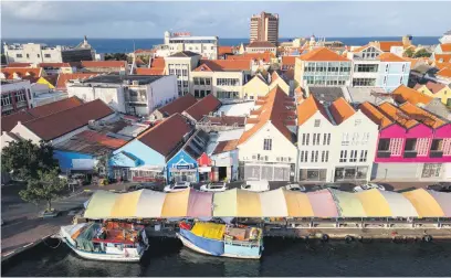  ?? Pictures: AFP ?? SHADOW OF ITS FORMER GLORY. An aerial view of the Punda floating market and colonial buildings on the waterfront of old town Willemstad, Curacao, in the Dutch Caribbean.