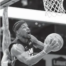  ?? NELL REDMOND AP ?? The Heat’s Jimmy Butler drives to the basket for two of his team-high 28 points against the Hornets on Sunday afternoon in Charlotte, N.C.