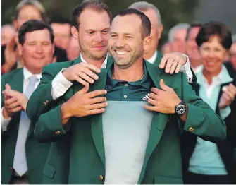  ?? BRANT SANDERLIN, ATLANTA JOURNAL-CONSTITUTI­ON ?? Defending Masters champion Danny Willett places the green jacket on Sergio Garcia following Garcia’s one-hole playoff win over Justin Rose at Augusta National.