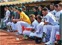  ?? Tribune News Service/bay Area News Group ?? The Oakland Athletics sit in the dugout as they watch the final out of their game against the Los Angeles Angels in the ninth inning of their MLB game at the Coliseum in Oakland on Sunday. The Los Angeles Angels defeated the Oakland Athletics 4-1.