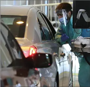  ?? (Arkansas Democrat-Gazette/Thomas Metthe) ?? Dr. Caleb Guthrey screens a patient Thursday at the drive-thru covid-19 testing site at the University of Arkansas for Medical Sciences in Little Rock.