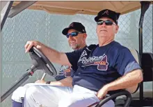  ??  ?? Atlanta Braves manager Brian Snitker, right, and bench coach Walt Weiss watch from a golf cart as the pitchers and catchers get loose during spring training baseball camp Thursday, Feb. 13, 2020, in North Port, Fla.