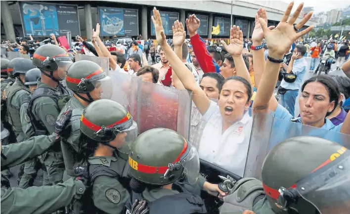  ?? REUTERS ?? Frente a frente. Manifestan­tes opositores se plantan ante a la Guardia Nacional venezolana en Caracas. En varios puntos de la capital las fuerzas de seguridad montaron retenes.
