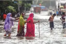  ?? PTI ?? People cross a flooded street at King Circle following the deluge in Mumbai yesterday.