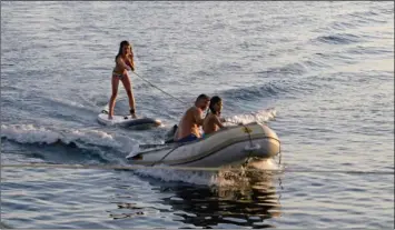  ??  ?? Un paddle reconverti en ski nautique. Dès qu’il s’agit d’être tractés, quelle que soit la manière, les enfants sont aux anges.