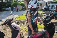  ?? ?? A young man arrives with an electric motorcycle at a roadside gathering in Havana.