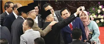  ?? FEDRIK TARIGAN/JAWA POS ?? AKLAMASI: Bambang Soesatyo berswafoto dengan anggota DPR dan DPD setelah rapat paripurna pemilihan pimpinan MPR di Senayan tadi malam.