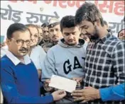  ??  ?? Delhi CM Arvind Kejriwal giving a ₹1cr cheque to the family of BSF martyr Narender Singh at Thana Kalan village in Sonepat. HT PHOTO