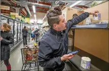  ?? LOS ANGELES TIMES/TNS HAYNE PALMOUR IV/ ?? Jaeci King, who said he’s been to several stores looking for toilet paper, picks up a roll of toilet paper while calling a friend to see if they want some at Jimbo’s in San Diego, California.