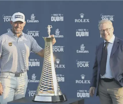  ??  ?? 0 Lee Westwood poses withe Race to Dubai Trophy alongside European Tour chief executive Keith Pelley